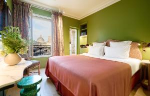 a green bedroom with a bed and a window at Hôtel Prince de Conti - Hôtel Rénové in Paris