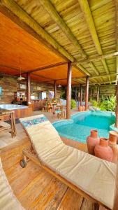 a large swimming pool in a pavilion with at Bangalô Maria Vista Mar, Luxo em Trancoso in Porto Seguro
