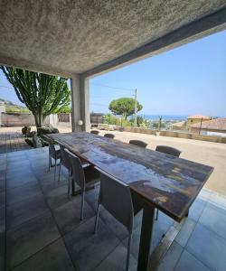 a large wooden table and chairs on a patio at Paradiso Apartment 4 people in Furiani