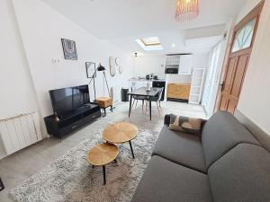 ein Wohnzimmer mit Sofa und Tisch in der Unterkunft Le Jardin Secret Apartment in Montbéliard