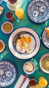 Una mesa cubierta con platos con huevos encima. en Riad Amelia Badr Soultan Room, en Tetuán
