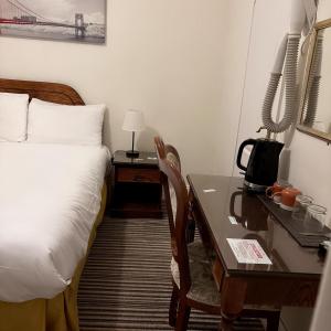 Una cama o camas en una habitación de Wimblehurst Hotel