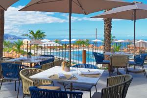 a restaurant with tables and chairs and a pool at Gran Hotel Taoro in Puerto de la Cruz +46 photos
