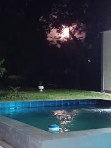 Una piscina de noche con un objeto azul en el agua. en Che Jazmin, your haven of peace and harmony, en Itá