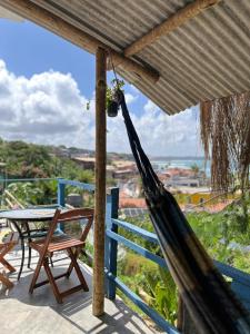 una hamaca en un porche con una mesa y sillas en VistaSurf Suites, en Pipa