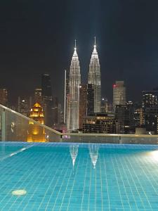 a swimming pool on top of a building with a city skyline at The Luxe KLCC by Infinitum in Kuala Lumpur