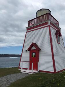 a lighthouse with a red door on the side of the water at Wildnorth Hotel in St. Anthony