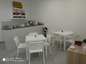 una sala da pranzo con tavoli bianchi e sedie bianche di B&B Il mandorlo a Polignano a Mare Altre 3 foto