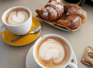 two cups of coffee and pastries on a table at B&B Il mandorlo in Polignano a Mare