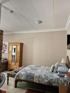 una camera da letto con un letto e un armadio in legno di Goedehoop a Somerset West Altre 25 foto