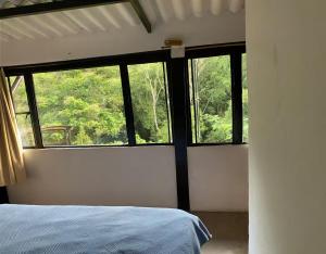 a bedroom with a bed and a large window at Finca El Cural in Sasaima