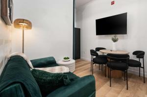 a living room with a green couch and a table at Casa Hotels McCaul- Modern Baldwin Village Suite in Toronto +26 photos