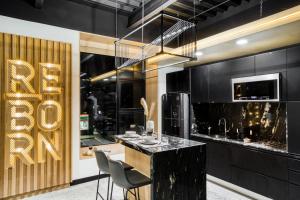 a kitchen with a bar with chairs and a chandelier at Downtown Designer Apartments by ULIV in Tijuana +16 photos