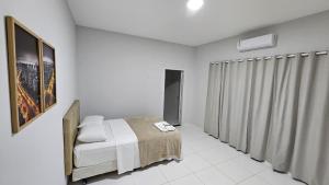 a white bedroom with a bed and a window at Hotel Almany in Palmas