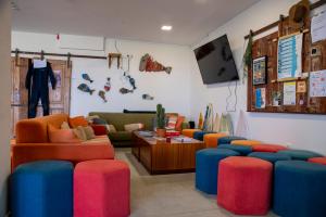 a living room with colorful couches and a tv at WOT Ericeira Surf Social in Ericeira