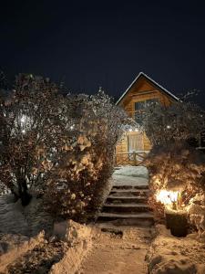 a log cabin with stairs in the snow at night at Domek w górach in Nowy Targ