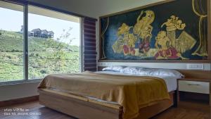 een slaapkamer met een groot schilderij boven een bed bij Cliff Inn Mountain Resort in Vagamon