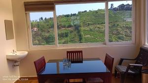 een eetkamer met een tafel en een groot raam bij Cliff Inn Mountain Resort in Vagamon