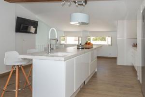 a white kitchen with a sink and a counter at Pico Mágina in Albanchez de Magina