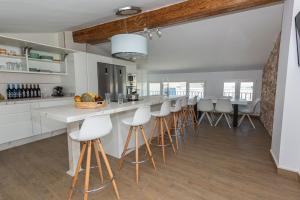 a kitchen with white countertops and bar stools at Pico Mágina in Albanchez de Magina