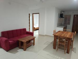 a living room with a red couch and a table at Purabi homestay in Silchar