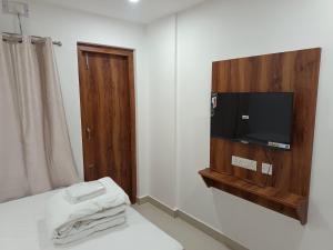 a room with a tv on a wall with a bed at Purabi homestay in Silchar