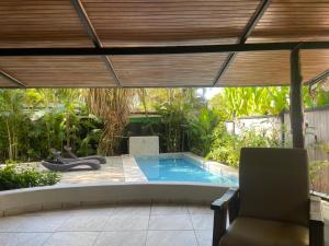 a swimming pool in a backyard with a wooden pergola at Beach Villa S in Santa Teresa Beach