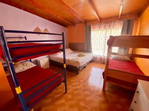 a bedroom with two bunk beds and a window at Hostal Nuevo Sol y Viento in San Pedro de Atacama