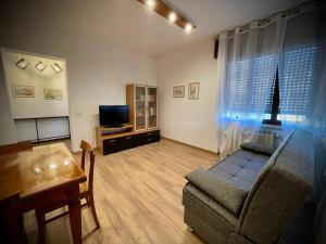 Una sala de estar con un sofá y un televisor. en Civico3, en Trissino