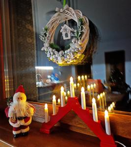 斯克拉斯卡波伦巴Furtka do Lasu的桌子上摆放着一组蜡烛和一个圣诞老人摆件。