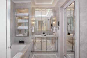 ein Badezimmer mit zwei Waschbecken, einer Badewanne und einem Spiegel in der Unterkunft Hotel d'Angleterre in Genf