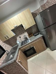 Una pequeña cocina con fregadero y refrigerador. en Oumhani5, en Sale