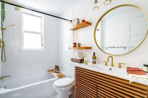 uma casa de banho com uma banheira, um WC e um espelho. em Jungle House Luxury Stays - Columbus Downtown Short North em Columbus