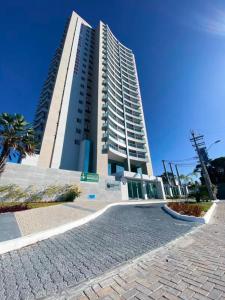 un edificio alto con una palma di fronte di Quarto master Fortaleza Sul a Fortaleza