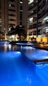 una grande piscina di acqua blu di fronte a un edificio di Quarto master Fortaleza Sul a Fortaleza