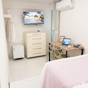 una camera da letto con un letto e una scrivania con un computer portatile di Quarto master Fortaleza Sul a Fortaleza