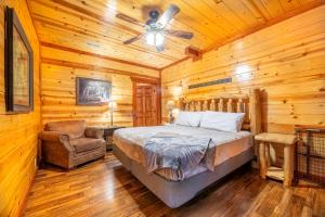 um quarto com uma cama, uma ventoinha de tecto e uma cadeira em Splash Mountain Lodge By Avada Properties em Little Cove mais 72 fotografias