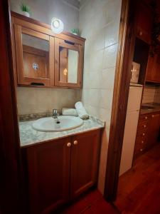 a bathroom with a sink and a mirror and a refrigerator at Tu rincón rústico con balcón y vistas - Erta 2 in Pla de l'Ermita