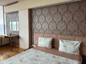 een slaapkamer met een bed met 2 kussens en een muur bij Мост сити АПП 138 ЛЮКС in Dnipro