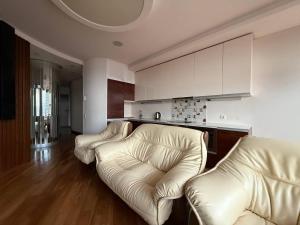 een woonkamer met 2 leren banken en een keuken bij Мост сити АПП 138 ЛЮКС in Dnipro +46 foto's