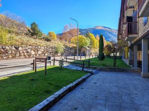 a street in a town with a stone wall at Tu rincón rústico con balcón y vistas - Erta 2 in Pla de l'Ermita