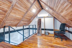 an attic office with a wooden ceiling and a chair at 5 Lofts En La Paraiso in Playa Grande