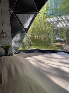 ein Zelt mit einem großen Fenster in einem Zimmer in der Unterkunft Tyla dviese in Kaciūniškiai