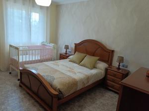 a bedroom with a bed and two night stands and a crib at Casa Castro in A Estrada