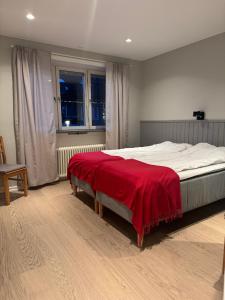 Åreguiderna - Bubblans lägenheter Åre Torg في آرا: غرفة نوم مع سرير مع بطانية حمراء عليه