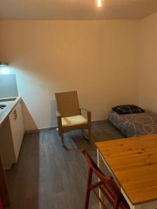a room with a bed and a chair and a table at Square Walliser près ZENITH in Strasbourg