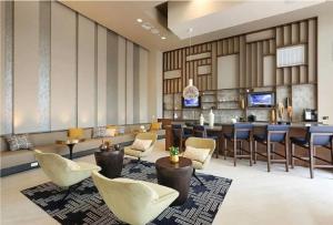 een lobby met stoelen en een bar in een hotel bij The Belladonna at Main Place in Orange