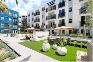 een appartementterras met tafels, stoelen en planten bij The Belladonna at Main Place in Orange