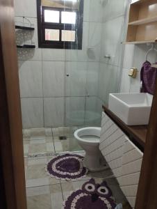 une salle de bains avec douche, toilettes et lavabo dans l'établissement Residence Lisboa, à Itanhaém