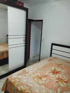 une chambre avec un lit, une commode et un miroir dans l'établissement Residence Lisboa, à Itanhaém